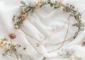 Boho Brautschmuck Flat-Lay mit Blütenkrone, zarten Goldketten und Mondstein-Anhänger