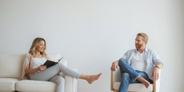 Paar genießt bewussten Freiraum zuhause – Frau liest, Mann entspannt
