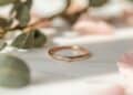 Puristischer Brautring in Roségold mit einzelnem Diamanten und Rosenblüten