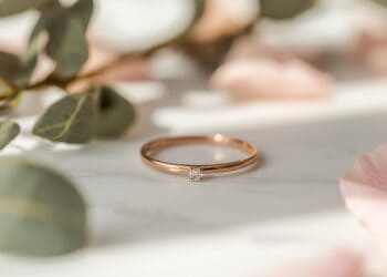 Puristischer Brautring in Roségold mit einzelnem Diamanten und Rosenblüten